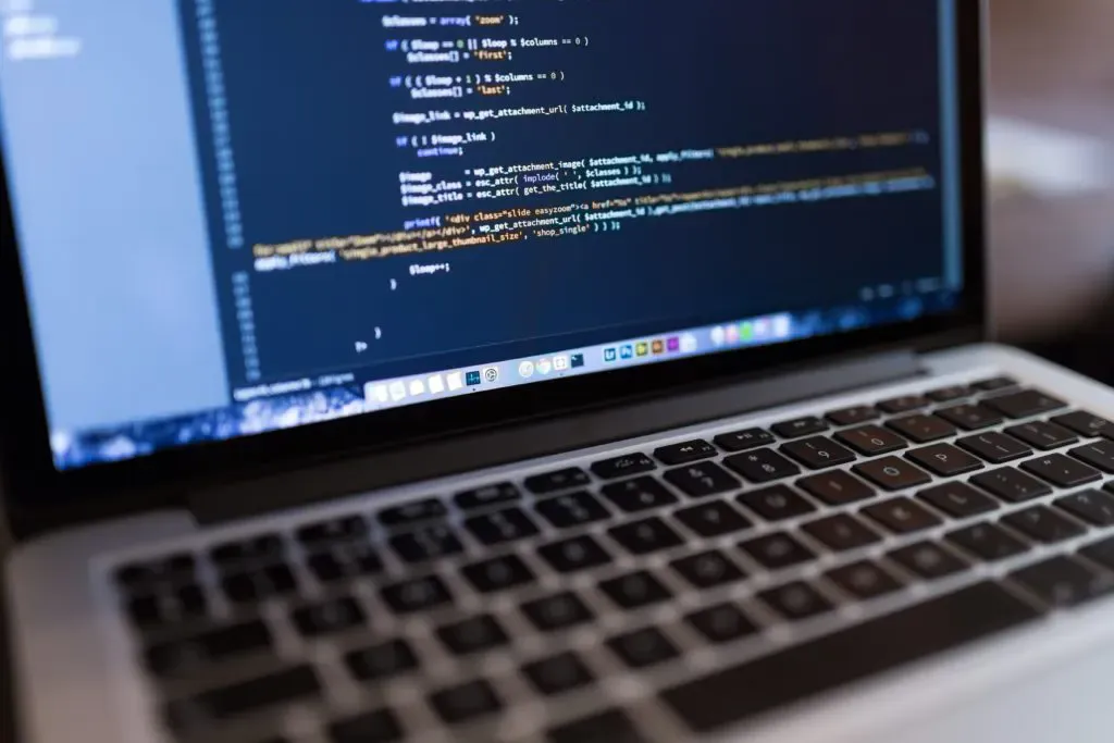 Laptop screen showing source code, Nasdron software development story cover