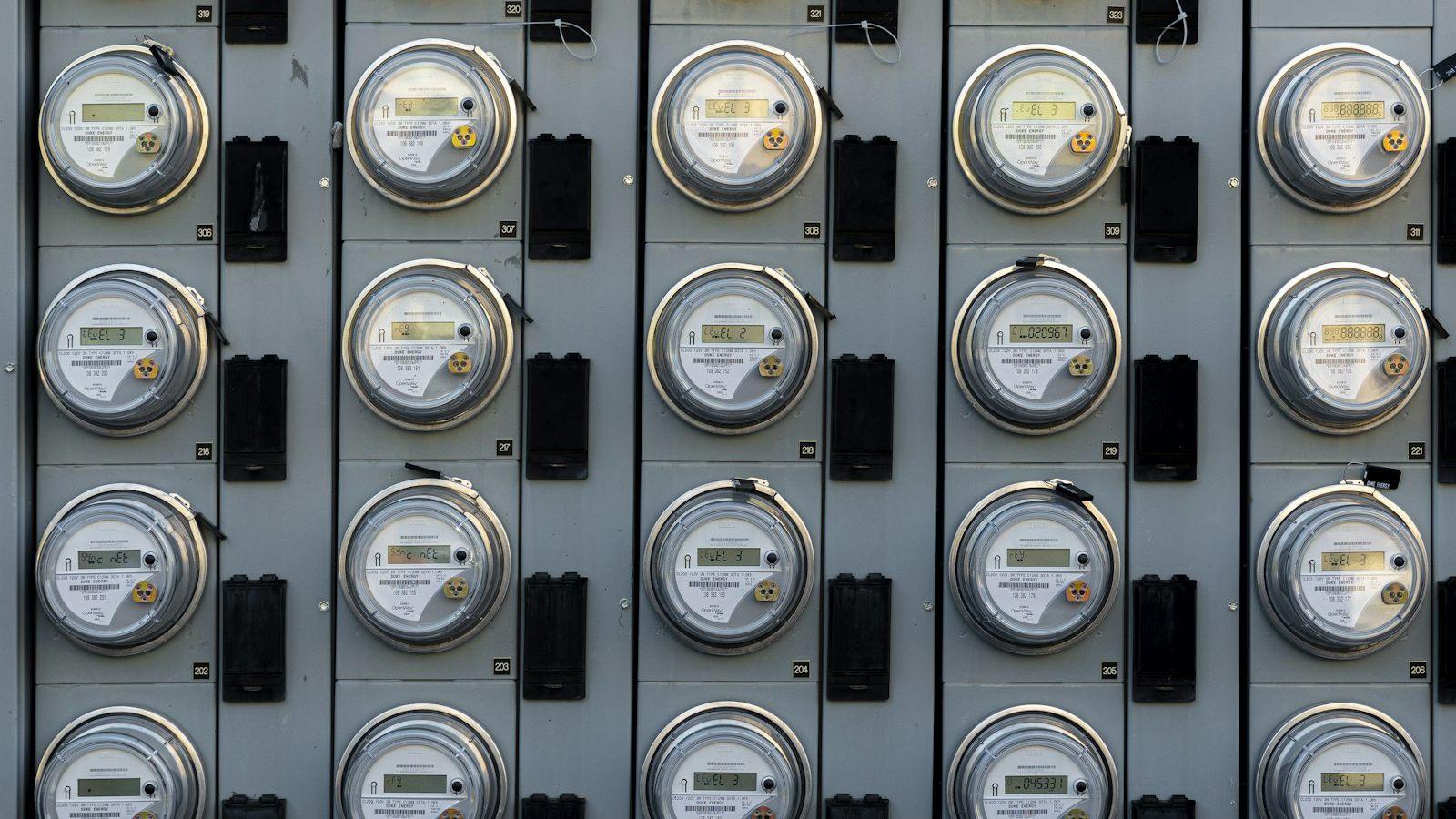 Rows of utility smart meters, each with a barcode label